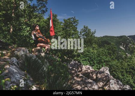 Frau und Hund entspannen sich nach dem Wandern in den Bergen Stockfoto