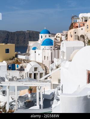 Blick auf das Dorf Oia in Santorini mit traditionellen weißen Häusern und blauen Kuppeln Kirchen, Griechenland Stockfoto