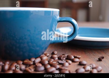 Tasse Kaffee mit gerösteten Bohnen im Vordergrund Stockfoto