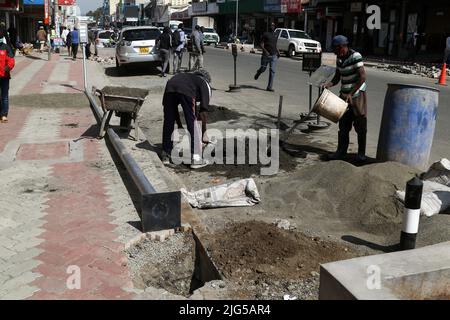 Nakuru, Kenia. 7.. Juli 2022. Arbeiter werden dabei gesehen, wie sie sich darauf vorbereiten, eine solarbetriebene Straßenleuchte auf der Kenyatta Avenue im zentralen Geschäftsviertel zu installieren. Die Regierung von Nakuru County mit Unterstützung der Weltbank installiert Solar-Straßenlaternen, um die Sicherheit der Stadt zu verbessern. Die solare Straßenbeleuchtung ist umweltfreundlich, sie nutzt erneuerbare Energie aus der Sonne und trägt daher nur wenig CO2-Emissionen bei, die für den Klimawandel verantwortlich sind. (Bild: © James Wakibia/SOPA Images via ZUMA Press Wire) Stockfoto