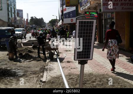 Nakuru, Kenia. 7.. Juli 2022. Arbeiter werden dabei gesehen, wie sie sich darauf vorbereiten, eine solarbetriebene Straßenleuchte auf der Kenyatta Avenue im zentralen Geschäftsviertel zu installieren. Die Regierung von Nakuru County mit Unterstützung der Weltbank installiert Solar-Straßenlaternen, um die Sicherheit der Stadt zu verbessern. Die solare Straßenbeleuchtung ist umweltfreundlich, sie nutzt erneuerbare Energie aus der Sonne und trägt daher nur wenig CO2-Emissionen bei, die für den Klimawandel verantwortlich sind. (Bild: © James Wakibia/SOPA Images via ZUMA Press Wire) Stockfoto