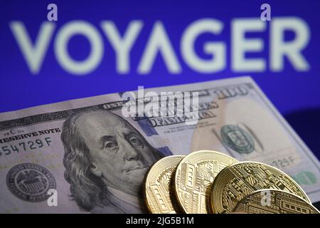 100 Krypto-Token in US-Dollar vor dem Bild und verschwommenes Firmenlogo von Voyager Digital Ltd auf verschwommenem Hintergrund. Konzept. Stafford, Großbritannien, Juli Stockfoto