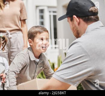 Ich bin der Mann des Hauses. Kurzer Schuss eines entzückenden kleinen Jungen, der die Lieferung seiner Mutter von einem männlichen Kurier abholte. Stockfoto