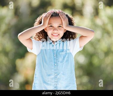 Klein zu sein ist eine große Sache. Aufnahme eines entzückenden kleinen Mädchens, das draußen steht. Stockfoto