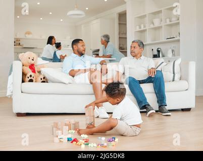 Die Ungezwungenheit des Familienlebens ist ein gesegneter Zustand. Aufnahme eines jungen Mannes und seines Vaters, der Zeit mit seinem Sohn verbringt. Stockfoto