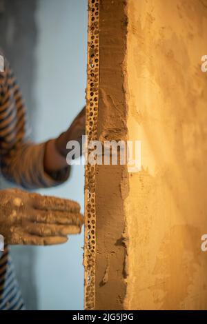 Der Mann renoviert das Haus. Reparatur der Wände in der Wohnung. Person arbeitet. Stockfoto