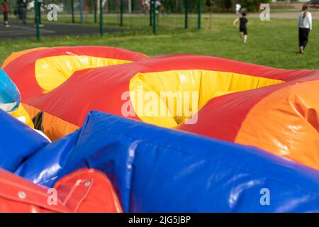 Aufblasbares Trampolin entlüften. Vergnügungspark-Treffen. Details zum Spielplatz. Hindernisparcours einrichten. Stockfoto