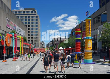 Montreal, Kanada - 3. Juli 2022: Gegend der Saint-Catherine Straße, wo das jährliche Montreal Jazz Festival stattfindet, mit unterhaltsamen Attraktionen für die Veranstaltung. Stockfoto