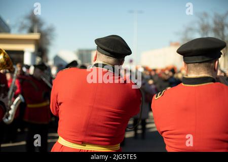 Militärkapelle in Parade. Trompeter auf der Straße. Trompeter spielt Melodie. Orchester in Russland. Rote zeremonielle Uniform. Stockfoto