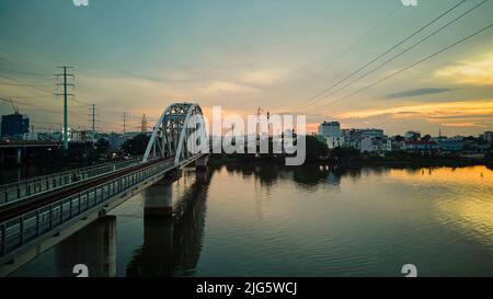 8. Juni 2022: Sonnenuntergang auf der Eisenbrücke über dem Saigon-Fluss, Ho-Chi-Minh-Stadt, Vietnam Stockfoto