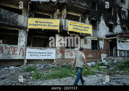 Borodyanka, Ukraine. 29.. Juni 2022. Ein Mann geht an den Ruinen eines zerstörten Wohnhauses in Borodyanka vorbei. Nach dem militärischen Versagen der Russen im Kyiv-Gebiet im März sind die einst leeren Städte nun voll von Bewohnern, die nach dem langen Krieg zurückkamen, um ihr Leben wieder aufzunehmen. (Foto von Alex Chan Tsz Yuk/SOPA Images/Sipa USA) Quelle: SIPA USA/Alamy Live News Stockfoto