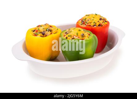Bunt gebacken mit Käse gefüllte Paprika mit Bohnen, Mais, Reis und Gemüse in einem weißen Kasserolle Backen isoliert auf weißem Hintergrund Stockfoto