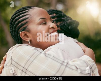 Eine Familie zu sein bedeutet, dass Sie ein Teil von etwas sind. Aufnahme einer Mutter und Tochter, die sich zu Hause umarmen. Stockfoto