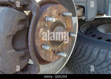 Bremsscheibe ohne Räder. Verrostete Scheibenbremse und Bremssattel am Fahrzeug. Automobilindustrie und Garagenkonzepte. Selektiver Fokus Stockfoto