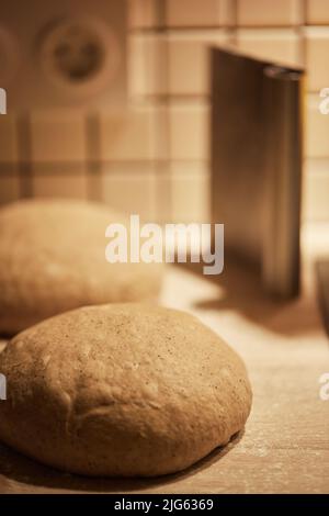 Der Prozess der Herstellung von Weizenbrot zu Hause. Teigform. Das Konzept der gesunden hausgemachten Speisen. Vertikales Foto. Stockfoto