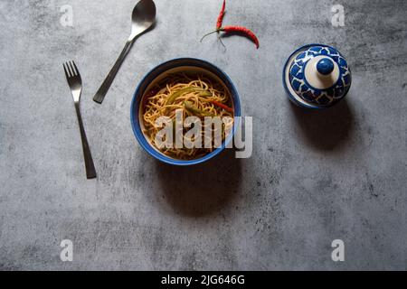 Gekochte Nudeln in einer Schüssel serviert. Draufsicht, selektiver Fokus. Stockfoto