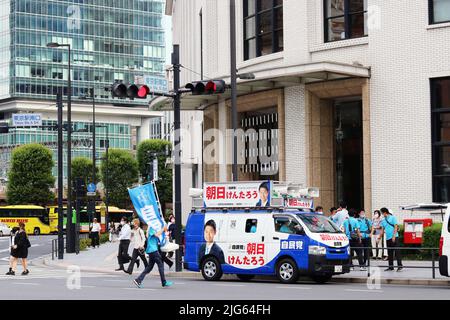 TOKIO, JAPAN - 7/5/2022: Unterstützer der Kandidaten des Abgeordnetenhauses und Wahlauto beim Kitte-Gebäude. Sie kämpft für Kentaro Asahi. Stockfoto