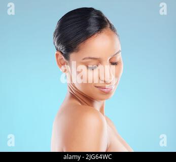 Schrecke Schönheit. Studioaufnahme einer attraktiven jungen Frau, die vor blauem Hintergrund posiert. Stockfoto
