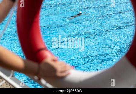 Detmold, Deutschland. 04.. Juli 2022. Blick durch einen Rettungsschwimmer am Pool im Hiddesen Freibad. Im Freibad in Detmold wird das Wasser nicht mehr mit Gas beheizt. Vor dem Hintergrund des russischen Angriffskrieges auf die Ukraine hatte die Stadt angekündigt, das Wasser in allen vier Außenpools nicht mehr zu heizen, um Gas für den Winter zu sparen. Quelle: Friso Gentsch/dpa/Alamy Live News Stockfoto