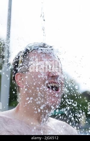 Detmold, Deutschland. 04.. Juli 2022. Eine Schwimmerin duscht sich am Hiddesen Außenpool. Im Freibad in Detmold wird das Wasser nicht mehr mit Gas beheizt. Vor dem Hintergrund des russischen Angriffskrieges auf die Ukraine hatte die Stadt angekündigt, das Wasser in allen vier Außenpools nicht mehr zu heizen, um Gas für den Winter zu sparen. (Um dpa-Korr 'Einfrieren gegen Putin? Der Außenpool in Detmold heizt nicht mehr Wasser') Quelle: Friso Gentsch/dpa/Alamy Live News Stockfoto