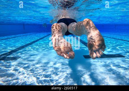 Detmold, Deutschland. 04.. Juli 2022. Ein Schwimmer schwimmt durch den Pool am Hiddesen Außenpool. Im Freibad in Detmold wird das Wasser nicht mehr mit Gas beheizt. Vor dem Hintergrund des russischen Angriffskrieges auf die Ukraine hatte die Stadt angekündigt, das Wasser in allen vier Außenpools nicht mehr zu heizen, um Gas für den Winter zu sparen. Quelle: Friso Gentsch/dpa/Alamy Live News Stockfoto