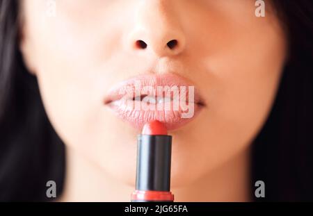 Kräftig und saftig. Aufnahme einer unkenntlichen Frau, die zu Hause Lippenstift anwendet. Stockfoto