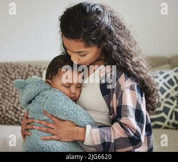 Shes die süßeste. Aufnahme einer jungen Mutter, die ihr Baby zu Hause umarmt. Stockfoto