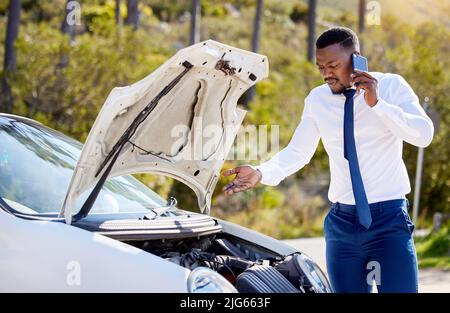 Ich brauche Euch hier so schnell wie möglich. Ausgeschnittene Aufnahme eines gutaussehenden Geschäftsmanns am Telefon mit Pannenhilfe nach einem Fahrzeugausfall. Stockfoto