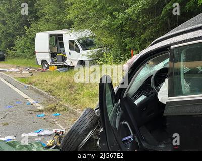 07. Juli 2022, Bayern, Fuchsmühle: Zwei beschädigte Autos stehen am Unfallort auf einer Staatsstraße in der Nähe von Fuchsmühle, einem Landkreis Hohenfels im Kreis Neumarkt in der Oberpfalz. Ein 20-jähriger Mann hatte am Donnerstagabend sein Auto in eine Gruppe von Leuten am Straßenrand gefahren. Dabei war ein 36-jähriger Mann getötet worden. Eine 25-jährige Frau und ein 40-jähriger Mann wurden per Rettungshubschrauber ins Krankenhaus gebracht. Foto: Haubner/vifogra/dpa Stockfoto