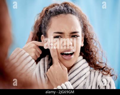 Noch eine Zit. Eine kurze Aufnahme einer attraktiven jungen Frau, die zu Hause einen Pickel im Badezimmer knallte. Stockfoto