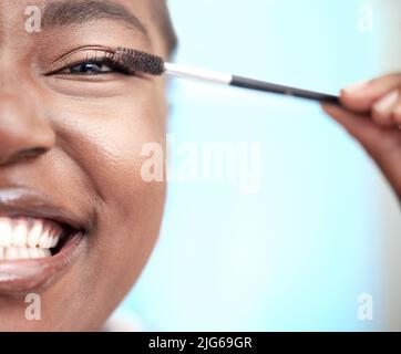 Ich liebe lange Wimpern. Nahaufnahme Porträt einer attraktiven jungen Frau, die Mascara im Badezimmer zu Hause anwendet. Stockfoto