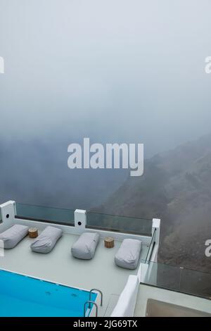 Atemberaubende Villa mit Swimmingpool im typischen weißgetünchten kykladischen Stil mit Blick auf die neblige Ägäis in Imerovigli Santorini Stockfoto