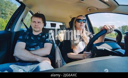 Ein Mann und eine Frau im Auto fahren durch die Stadt. Stockfoto