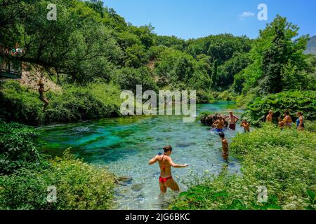 Muzina, Albanien - Touristen baden im Syri i Kaltër, DEM BLAUEN AUGE, ist mit 6 m³/s die wasserreichste Quelle des Landes. Das Wasser kommt aus Stockfoto