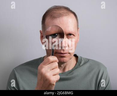 Mann, der durch das Lupenfenster schaut. Hochwertige Fotos Stockfoto