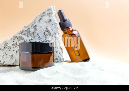 Set von unbranded Kosmetik in dunklem Glas-Paket für die Hautpflege. Beauty Serum und Gesichtscreme für die alternde Haut. Anti-Age-Effekt Stockfoto