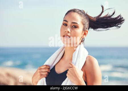 Bereit, etwas Schweiß aufzuwischen. Aufnahme einer jungen Frau, die während eines Trainings eine Pause einnahm. Stockfoto