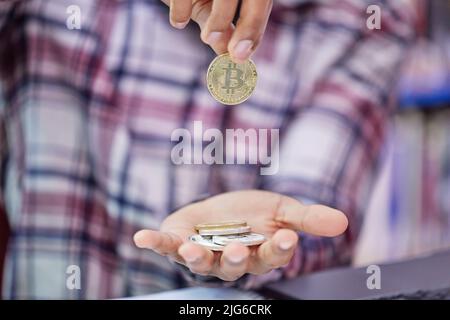 Wie viel ist es für Sie wert. Aufnahme eines nicht erkennbaren Mannes, der Bitcoins hält. Stockfoto