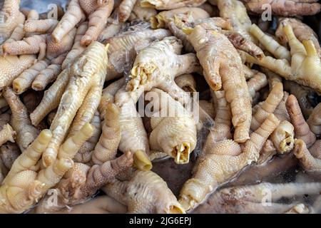 Ein Haufen roher Hühnerkrallen, die auf einem thailändischen Markt angeboten werden Stockfoto