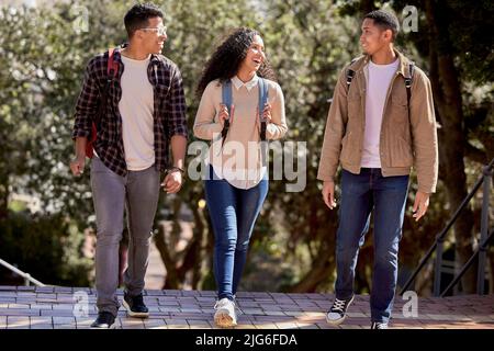 Lachen ist die beste Medizin. Aufnahme einer Gruppe von Studenten, die gemeinsam durch den Campus gehen. Stockfoto