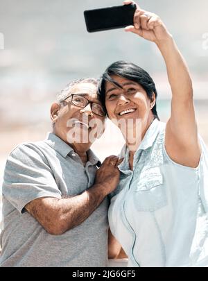Immer noch Erinnerungen an jeden Tag. Aufnahme eines älteren Paares, das ein Selfie in der Natur gemacht hat. Stockfoto