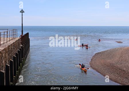 AXMOUTH, DEVON, ENGLAND - JULI 12. 2020: Männer und Frauen in Kanus machen sich gegen die Strömung in der Mündung der Axe in der Nähe von Axmouth auf den Weg Stockfoto