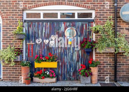 Schwarze Leben sind wichtig, Ende Rassismus Zeichen oder Botschaften auf bunt bemalten Türen mit Blumen Stockfoto
