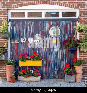 Schwarze Leben sind wichtig, Ende Rassismus Zeichen oder Botschaften auf bunt bemalten Türen mit Blumen Stockfoto