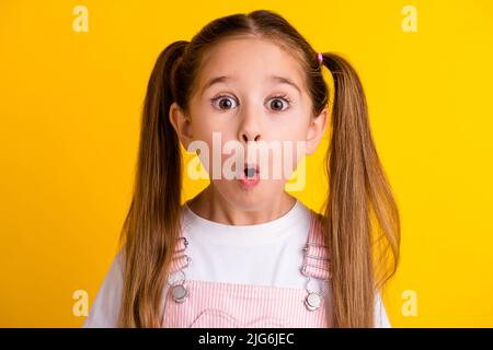 Foto von ziemlich beeindruckt Schule Mädchen tragen Sommer Outfit große Augen isoliert gelbe Farbe Hintergrund Stockfoto