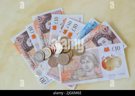 Britische moderne Banknoten und Münzen in der Hand. Stockfoto