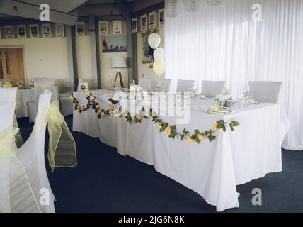 Ein Tisch an einem Hochzeitsempfang, der für ein Hochzeitsfrühstück ausgelegt ist Stockfoto