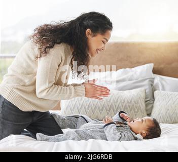 Singe mit Mama, ich kenne die Worte. Aufnahme eines entzückenden Jungen und seiner Mutter, die sich während des Windelwechsels zu Hause anklebten. Stockfoto