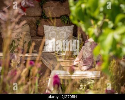 Holzgartensitz mit Streuspitzen, Teil eines Showgartens in der Hampton Court Palace Gartenschau in London. Stockfoto