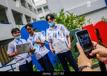 Antipolo, Philippinen. 08.. Juli 2022. Die Schüler posieren für ein Foto nach einer Abschlussfeier an der San Jose National High School, Antipolo. Nach zwei Jahren der Pandemie auf den Philippinen führen öffentliche und private Schulen langsam einen persönlichen Graduierungsritus durch. Kredit: SOPA Images Limited/Alamy Live Nachrichten Stockfoto